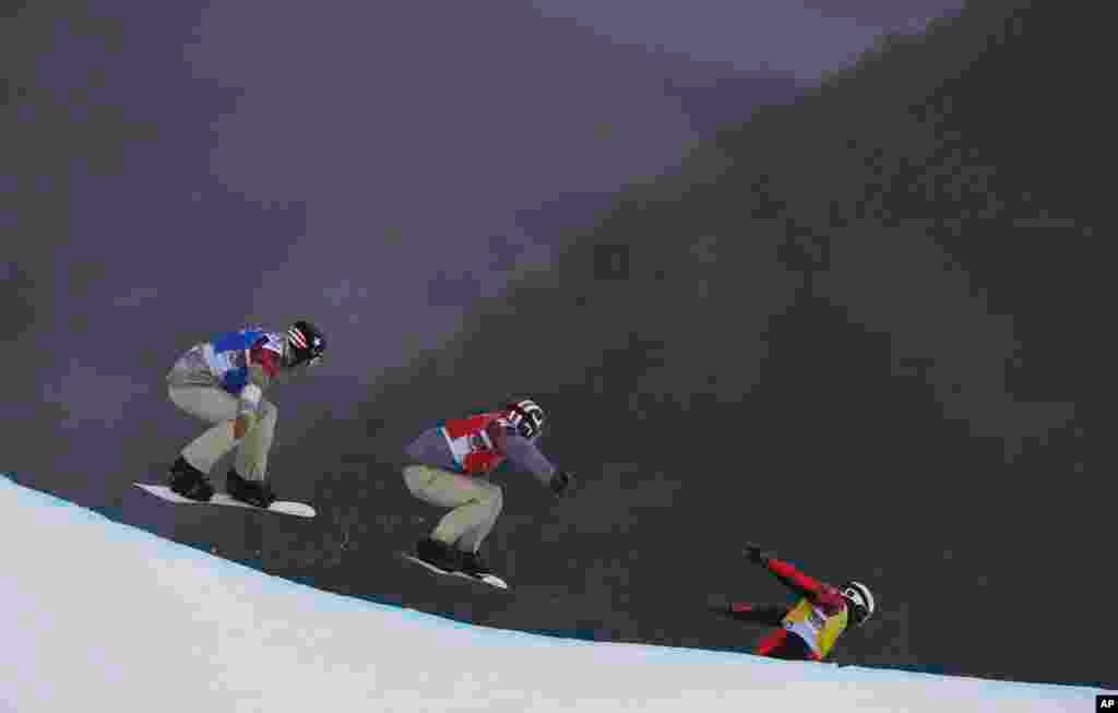 Alex Deibold of the United States, Trevor Jacob of the United States and Norway's Stian Sivertzen go off a drop during the first men's snowboard cross semifinal at the 2014 Winter Olympics, Feb. 18, 2014.