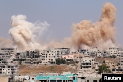 FILE - Smoke rises after airstrikes on a rebel-held part of the southern city of Daraa, Syria, June 15, 2017.