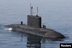 FILE - Iranian military personnel stand on a submarine during a naval parade on the last day of the Velayat-90 war game in the Sea of Oman near the Strait of Hormuz in southern Iran, Jan. 3, 2012.