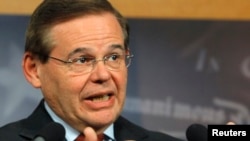 A young woman views a photo of Buth Oeun, a fortune teller in Preah Sihanoukville, who uses cards to tell people’s fortune.