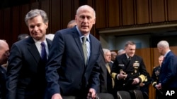 Direktur Biro Investigasi Federal AS (FBI) Christopher Wray (kiri) dan Direktur Intelijen Nasional Dan Coats (kedua dari kiri) tiba untuk menghadiri rapat dengar pendapat di Washington, 13 Februari 2018.
