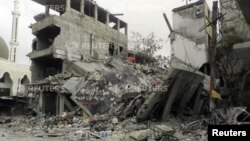Damaged buildings are pictured after what activists said was shelling by forces loyal to Syria's President Bashar al-Assad, in Zamalka near Damascus, Mar. 16, 2013. 