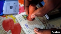 Un agent électoral appose le sceau sur le bulletin d’un électeur qui vient de voter lors des législatives à Abidjan, Côte d’Ivoire, 18 décembre 2016. REUTERS/Thierry Gouegnon