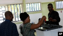 A woman casts her vote at the Ba Oumar school voting station of Libreville, Gabon, December 17, 2011.
