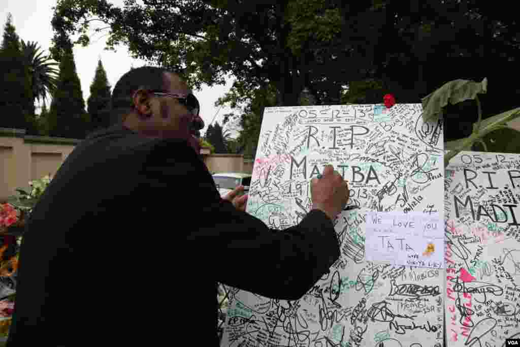 Mandela fans leave tributes outside his former home in Houghton, South Africa. (Hannah McNeish for VOA)