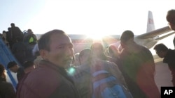 Foreigners and North Koreans, facing increased safety measures to prevent the possible spread of Ebola, board a Beijing-bound Air Koryo flight in Pyongyang, Oct. 28, 2014.