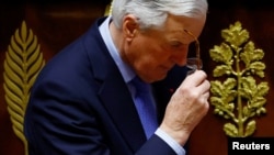 French Prime Minister Michel Barnier removes his glasses after he delivered a speech during a debate on a no-confidence motion in the National Assembly, which then approved the motion on Dec. 4, 2024.
