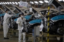 工人陪在口罩在位于湖北武汉市的东风本田汽车装配线上工作。（2020年4月8日）