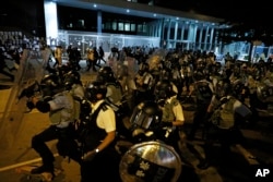 Police officers in anti-riot gear clear protesters from the Legislative Council in Hong Kong, during the early hours of Tuesday, July 2, 2019. (AP Photo/Vincent Yu)