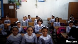 Palestinian schoolgirls sit inside a classroom at an UNRWA-run school, on the first day of a new school year, in Gaza City, Aug. 29, 2018.