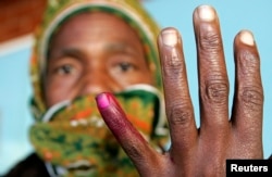 FILE - A woman shows her ink-stained finger after voting in Zimbabwe's presidential and parliamentary elections in Harare, March 29, 2008.