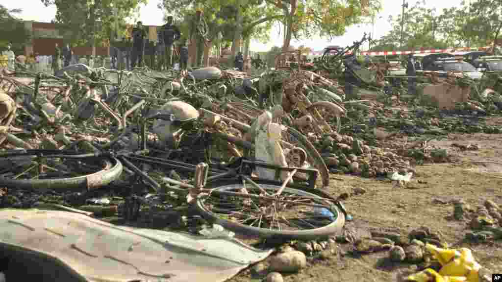 'Yan sanda a tsaye a kusa da tarkacen da ya watsu bayan tashin bam a babban Masallacin Jumma'a na Kano, Jumma'a 28 Nuwamba 2014.