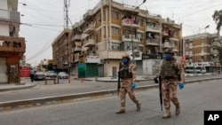 FILE - Iraqi security forces are seen on patrol in central Baghdad, Iraq, April 7, 2020. 