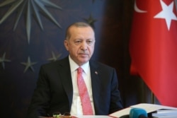 Turkish President Recep Tayyip Erdogan, listens during a teleconference with his cabinet in Istanbul, May 11, 2020.