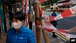 A woman wearing face mask walks on a street in Hong Kong, Feb. 18, 2020. 
