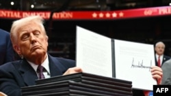 1月20日，特朗普向在华盛顿特区第一资本体育馆的支持者展示他签署的一项行政命令。