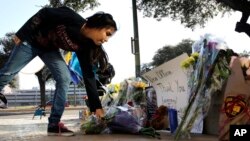 Faith Reyna leaves flowers at a make-shift memorial for slain San Antonio police officer Benjamin Marconi, 50, a 20-year veteran of the force, Nov. 21, 2016. Marconi was fatally shot during a traffic stop near police headquarters Nov. 20, 2016.