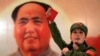 FILE - A Chinese, dressed as a Red Guard and holding a "Little Red Book" (quotations of Chairman Mao), performs in front of a portrait of the late Chairman Mao Zedong at a restaurant named "Red Classic" in Beijing.