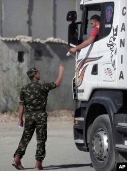 A Palestinian security officer controls traffic of imported goods at the Kerem Shalom border crossing on the Gaza Strip-Israel border, Nov. 1, 2017.