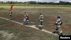FILE - Indian Border Security Force soldiers walk across the open border with Bangladesh to attend a flag meeting in West Bengal, India, June 20, 2015. Indian officials said Sept. 23, 2017, that because of security risks, border forces have been authorized to prevent Rohingya Muslims from entering the country.