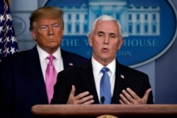 President Donald Trump listens as Vice President Mike Pence speaks during a news conference about coronavirus in the Brady Press Briefing Room at the White House, Feb. 26, 2020, in Washington.