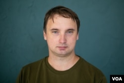 FILE - Four men in plain clothing detained journalist Andrey Kuznechyk outside his Minsk apartment on Nov. 25, 2021.