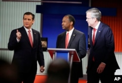Republican presidential candidates Sen. Ted Cruz, left, retired neurosurgeon Ben Carson and former Florida Gov. Jeb Bush chat during the Fox Business Network Republican presidential debate at the North Charleston Coliseum in North Charleston, S.C., Jan. 14, 2016.