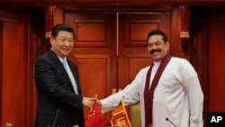 Sri Lankan President Mahinda Rajapaksa, right, shakes hands with Chinese President Xi Jinping during their meeting in Colombo, Sri Lanka, Sept.16, 2014.