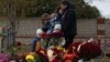 Меморіалу жертвам російського ракетного обстрілу в селі Гроза під Харковом, Україна, неділя, 8 жовтня 2023 р. У доповіді слідчих ООН мовиться, що Росія, ймовірно, несе відповідальність за смерть 59 мирних жителів у сільському кафе, у яке влучила ракета на початку жовтня. (AP)