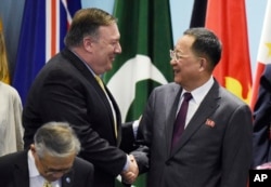 FILE - U.S. Secretary of State Mike Pompeo, left, greets North Korea's Foreign Minister Ri Yong Ho as they prepare for a group photo at the 25th ASEAN Regional Forum Retreat in Singapore, Aug. 4, 2018.