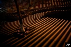 A boy plays as floodlights from the United States filter through the border wall, Jan. 11, 2019, in Tijuana, Mexico. The partial U.S. government shutdown has now become the longest closure in U.S. history as President Donald Trump and nervous lawmakers look for a way out of the mess.