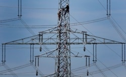 FILE - In this April 11, 2011 file photo, workers of the German energy company RWE prepare power supply on a high power pylon in Moers, Germany. The world's facing an energy crunch. (AP Photo)