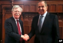 U.S. National Security Adviser John Bolton, left, and Russian Foreign Minister Sergey Lavrov shake hands prior to their talks in Moscow, Oct. 22, 2018.