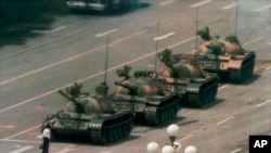 FILE - In this June 5, 1989, photo, a Chinese man stands alone to block a line of tanks heading east on Beijing's Changan Boulevard in Tiananmen Square. 