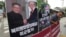 FILE - A photo showing U.S. President Donald Trump and North Korean leader Kim Jong Un is displayed as a member of People's Democratic Party stands to oppose military exercises between the United States and South Korea, near the U.S. Embassy in Seoul, South Korea.