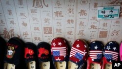FILE - Chinese made children shoes carying a Chinese map and U.S. flags are on display for a sale at a shop in Beijing, July 13, 2018. 