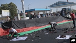 Afghans gather property, left behind by victims of a deadly explosion that struck a protest march by ethnic Hazaras, in Kabul, Afghanistan, July 23, 2016.