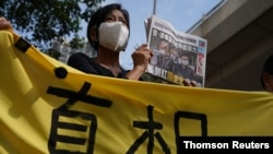 A supporter holds a copy of Apple Daily newspaper during a court hearing outside West Magistrates’ Courts, after police charge two executives of the pro-democracy Apple Daily newspaper over the national security law, in Hong Kong, June 19, 2021.