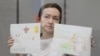 Alsu Kurmasheva, a Russian-American journalist for Radio Free Europe/Radio Liberty who is in custody after she was accused of violating Russia's law on foreign agents, holds drawings from her supporters as she attends a court hearing in Kazan, Russia, on May 31, 2024.
