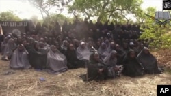FILE - In this photo taken from video by Nigeria's Boko Haram terrorist network, Monday May 12, 2014 shows the alleged missing girls abducted from the northeastern town of Chibok. The new video purports to show dozens of abducted schoolgirls, covered in jihab and praying in Arabic. 