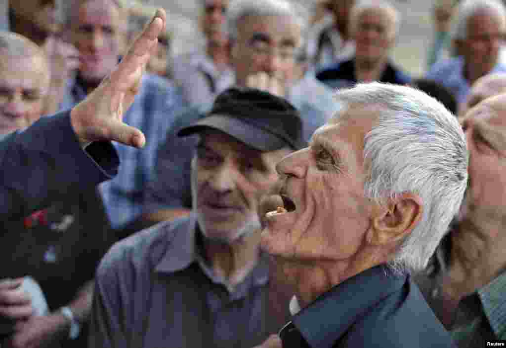 A pensioner argues with an official as he tries to enter a National Bank branch to receive part of his pension in Athens, Greece, July 6, 2015.