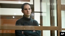 FILE - Wall Street Journal reporter Evan Gershkovich stands in a glass cage in a courtroom at the Moscow City Court in Moscow, Russia, on Dec. 14, 2023.