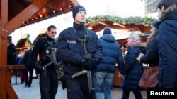 German police patrol with submachine guns at the Christmas market at Breitscheid square in Berlin, Dec. 30, 2016. An Tunisian attacker ploughed through a crowd at the market with a truck, killing at least twelve people.