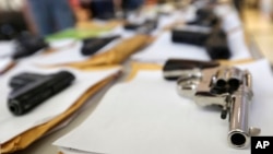 FILE - Chicago police display some of the thousands of illegal firearms they have confiscated in 2014 in their battle against gun violence in Chicago, July 7, 2014.