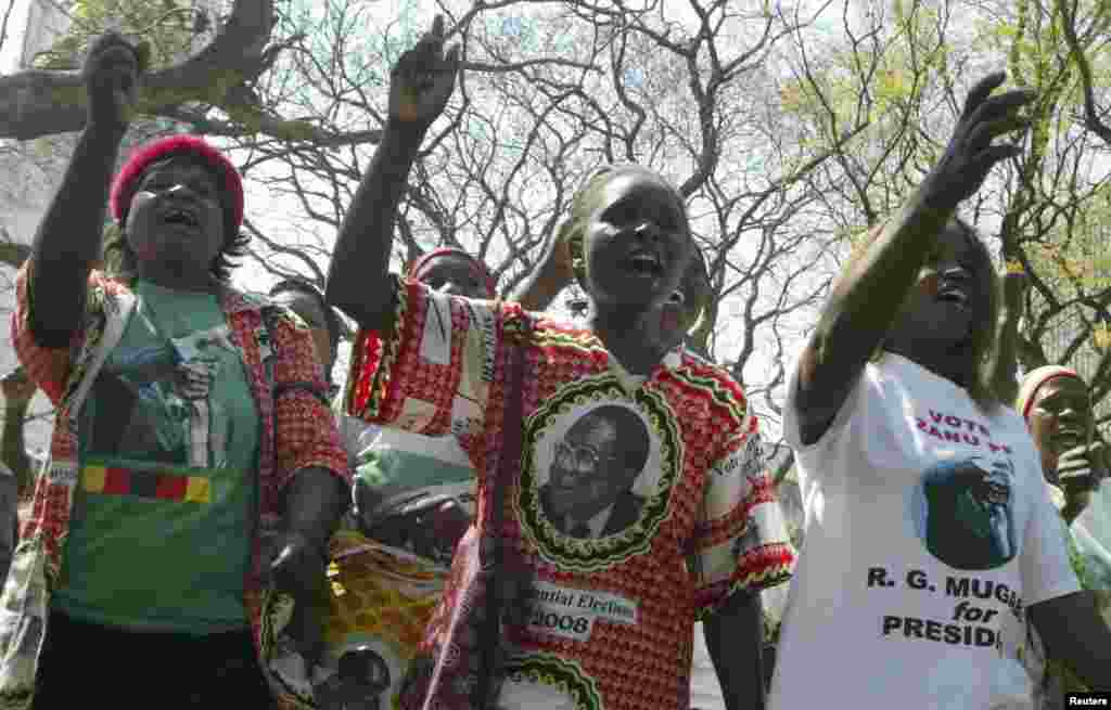 Zimbabwe's ruling ZANU-PF supporters salute President Robert Mugabe before the opening of the Parliament in Harare, August 26, 2008. Mugabe was jeered on Tuesday as he opened parliament in defiance of opposition objections, but voiced optimism for a power-sharing deal to end political turmoil.