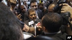 Mohamed Morsi, the Muslim Brotherhood's presidential candidate, is surrounded by reporters in Cairo, Egypt, May 26, 2012.