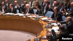 Members of the United Nations Security Council raise their hands as they vote unanimously to approve a resolution eradicating Syria's chemical arsenal at a Security Council meeting during the 68th United Nations General Assembly in New York, Sept. 27, 2013. 