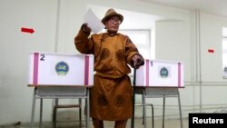 一名身穿传统服装的男子参加蒙古国总统选举，在乌拉巴托的一处投票站投下一票。（2013年6月26日）