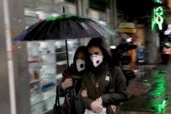 Pedestrians wear masks and gloves to help guard against the Coronavirus in downtown Tehran, Iran, Feb. 25, 2020.