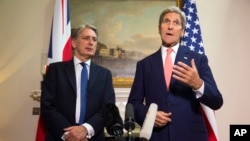 Menteri Luar Negeri AS John Kerry (kanan) menjawab pertanyaan tentang Suriah dalam konferensi pers, didampingi Menteri Luar Negeri Inggris Philip Hammond, di London (19/9). 